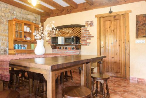 una cocina con una mesa de madera con un jarrón. en Conjunto Rural la Tejedora. Albergue y estudios familiares. en Rasines