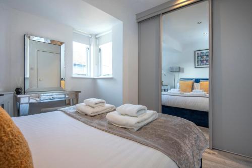 a bedroom with two towels on a bed with a mirror at 2 Bed town house with Garden in Hackney, London in London
