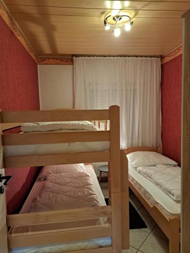 2 Etagenbetten in einem Zimmer mit Fenster in der Unterkunft Haus Windmühle Erdgeschoß in Norden