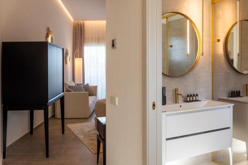 a bathroom with a sink and a tv in a room at Dionis Boutique Hotel & Spa in Jávea