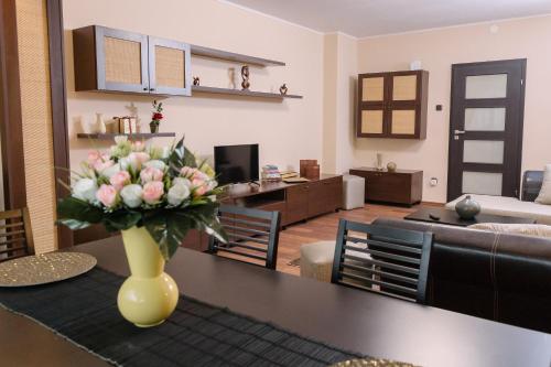 a vase of flowers on a table in a living room at Apartament Premium Borealis in Timişoara