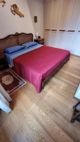 una camera da letto con un grande letto con una coperta rosa di Stanza dei Mercanti a Orvieto