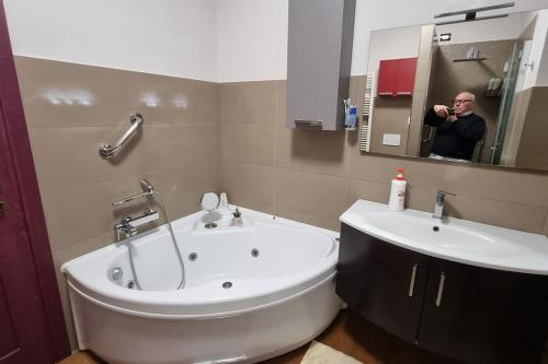 un hombre tomando una foto de un baño con bañera y lavabo en Stanza dei Mercanti, en Orvieto