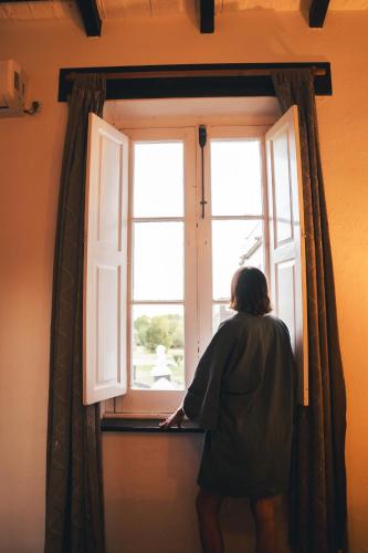 a woman looking out of a window at HOSTAL CRUZ CHICA in La Cumbre