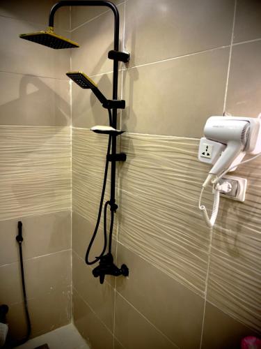 a shower with a blow dryer in a bathroom at Locanda pyramids view in Cairo