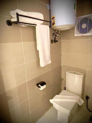 a bathroom with a white toilet and towels at Locanda pyramids view in Cairo