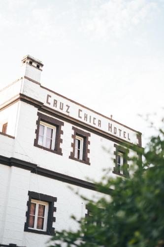 a white building with a sign that reads flux chef hotel at HOSTAL CRUZ CHICA in La Cumbre