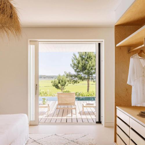 a bedroom with a door leading to a patio at Campo de Arroz in Carvalhal