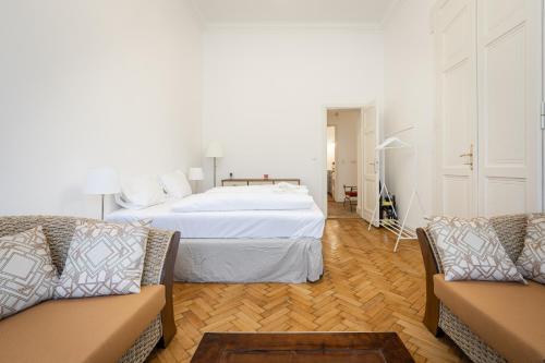 ein Schlafzimmer mit einem Bett und zwei Sofas in der Unterkunft Court Crossing Apartment in Budapest