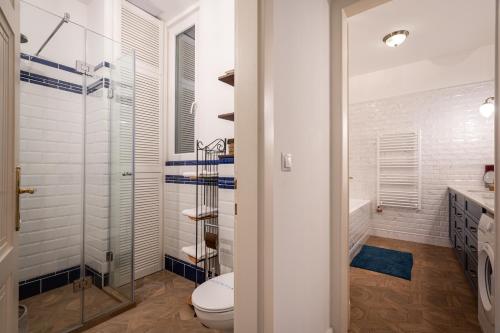 ein Bad mit einem WC und einer Glasdusche in der Unterkunft Court Crossing Apartment in Budapest