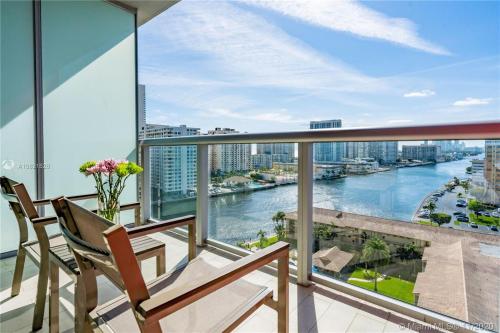 a balcony with chairs and a view of a river at Water View Building With Pool - 5-Min Walk To The Beach - Cozy Studios in Hallandale Beach