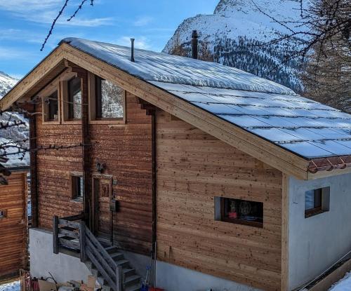 a log cabin with a snow covered roof at Chalet Adler in Saas-Fee