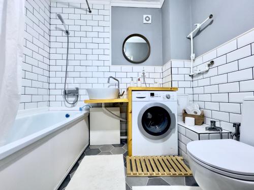 a bathroom with a washing machine and a sink at Двушка около Академии Scandinavian Style in Atyrau