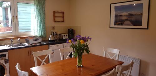 a kitchen with a table with a vase of flowers on it at Tigh na Camus in Glenelg