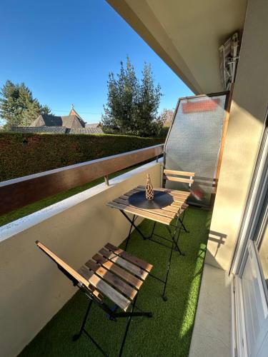 a table and a bench on a balcony at Apt Évreux 900m de la gare in Évreux
