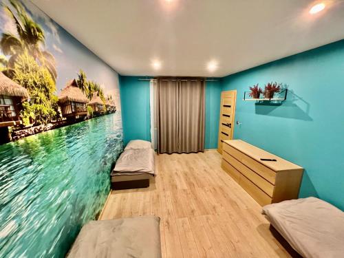 1 dormitorio con 2 camas y una pintura del agua en Good Rooms Apartamenty z 3 sypialniami parking en Lodz