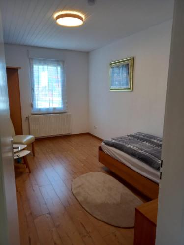 Cette chambre blanche dispose d'un lit et d'une fenêtre. dans l'établissement Schöne Ferienwohnung in Gernsbach, à Gernsbach
