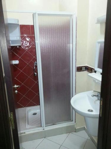 uma casa de banho com um chuveiro e um lavatório. em BH APPART em Temara