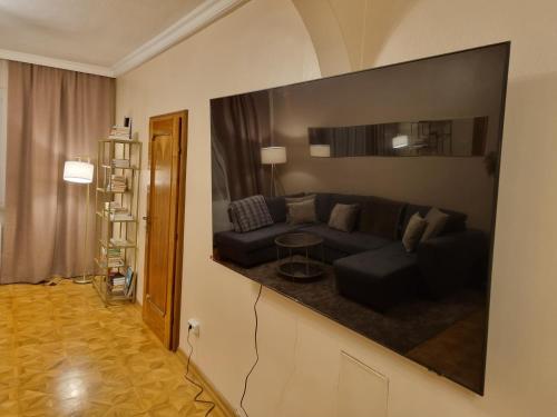 uma sala de estar com um sofá e uma televisão na parede em Villa with private Sauna and Jacuzzi, 8 min from Schloss Schöbrunn em Viena
