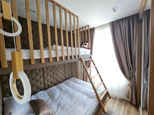 a bunk bed with a ladder in a room at Sky Lux Apartments in Jahorina