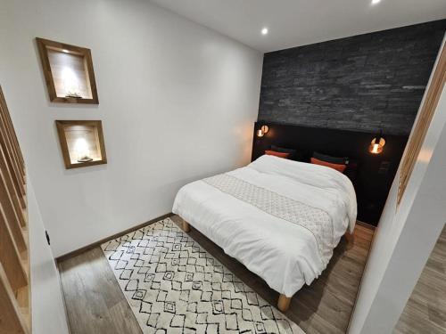 een kleine slaapkamer met een bed met witte lakens bij L'ÉTOILE AZ - vue lac - Sauna privé in Tresserves