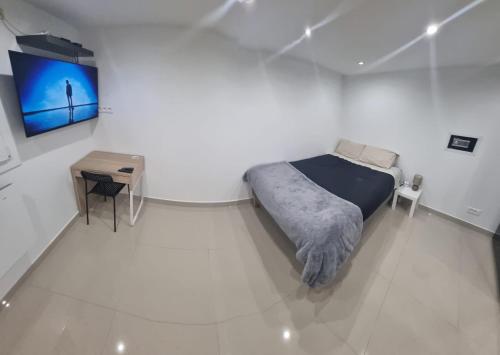 une chambre avec un lit et une télévision sur un mur dans l'établissement Studio Arena - Groupama stadium Lyon, à Meyzieu