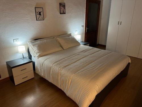 a bedroom with a bed and a nightstand with two lamps at Il Pentolo in Sansepolcro