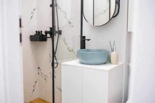 a bathroom with a blue sink and a mirror at Hi-lux Ultracentral - 4BR Superior - Amazing View in Bucharest