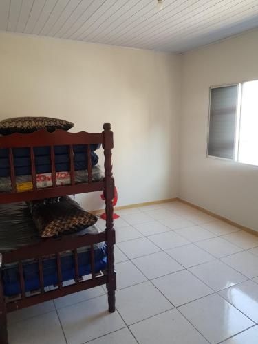 een kamer met een tegelvloer en een houten plank bij Apartamento Perto da Praia in Praia Grande