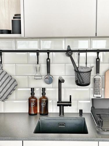 a kitchen counter with a sink and utensils at Nanisgarten - Grannys flat in Obergesteln