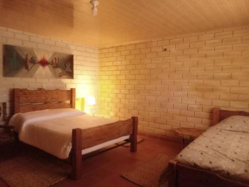 a bedroom with two beds and a bench in it at Risgua in Tinjacá