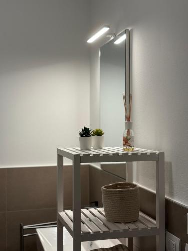 a white table with plants on it in a bathroom at SUITE NAVIGLIO 26 in Parma