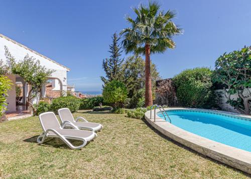 un patio con 2 tumbonas y una piscina en TOP VILLA Casa Anna Private Pool Garden Seaview en Benalmádena