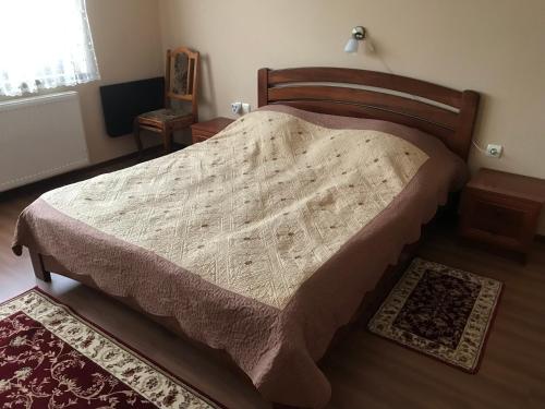 Un dormitorio con una cama grande con una manta. en Квітковий двір, en Golubinoye