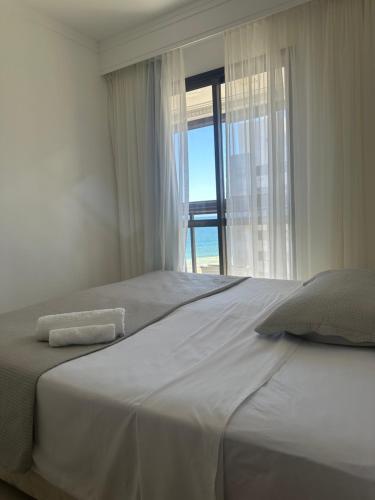 Un dormitorio con dos camas y una gran ventana. en Surpreenda-se excelente apartamento com vista mar, en Salvador