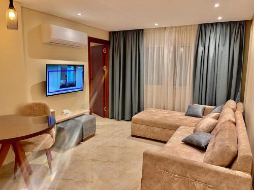 een grote woonkamer met een bank en een tv bij Sun gate house in Caïro