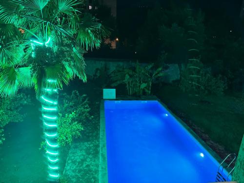 a swimming pool with blue lights next to a palm tree at GARRIOTT TBILISI in Tbilisi City