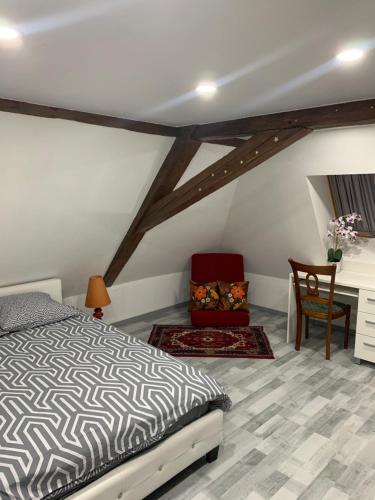 1 dormitorio con cama, silla y escritorio en Chambre rustique avec double lit et sa salle de bain privée, en Urbès