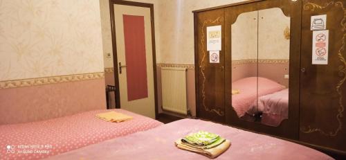 a small room with two beds and a mirror at Etablissement commun avec chambre privé tranquille avec jardin a 10 min a pied de la gare de Fleury-les-Aubrais et 2 min d Orléans in Fleury-les-Aubrais