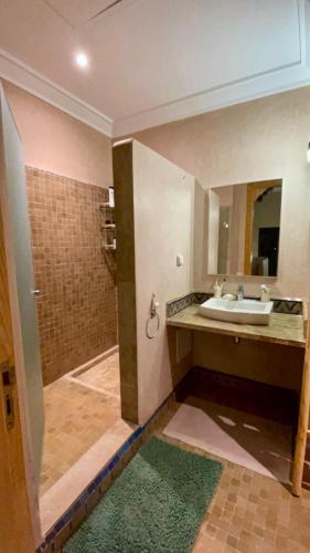 a bathroom with a sink and a shower with a mirror at Private Villa BSF - Hot Pool & Spa - Palm Golf in Marrakech