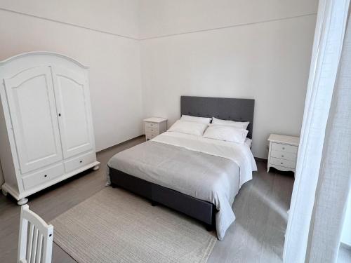 a white bedroom with a bed and a white cabinet at Donna Anna in Polignano a Mare