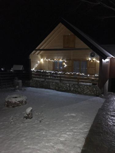 a house with lights in the snow at night at Holiday Home JASEN in Kolašin