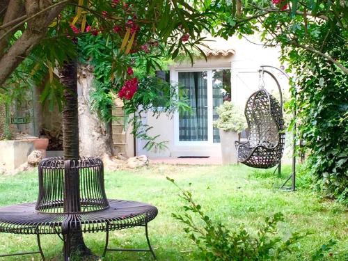 ogród z 2 krzesłami, stołem i huśtawką w obiekcie Clos de la Colombe w mieście Pouzols