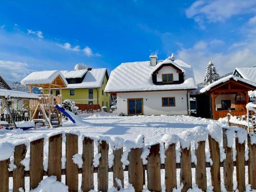 a house covered in snow with a fence at Chalet Mama in Pruggern