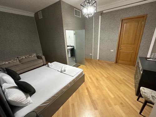 a bedroom with a bed and a couch and a table at GARRIOTT TBILISI in Tbilisi City