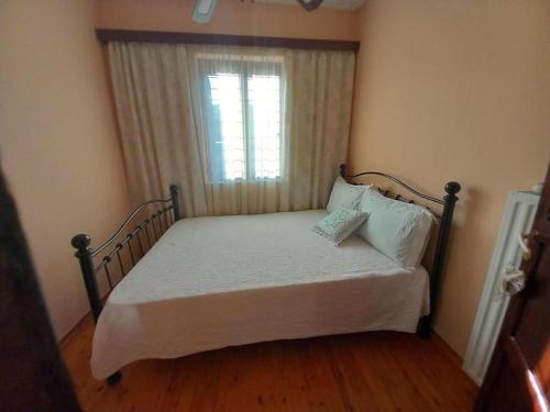 a bedroom with a bed with a window and a bed frame at Andreas House in Valíra