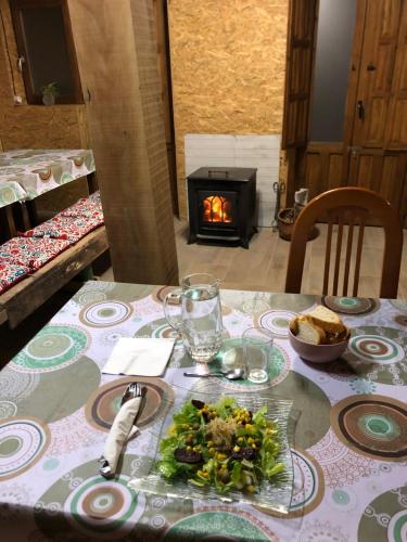 a table with a plate of food and a fireplace at Refugi MARILLUNA in Montblanquet