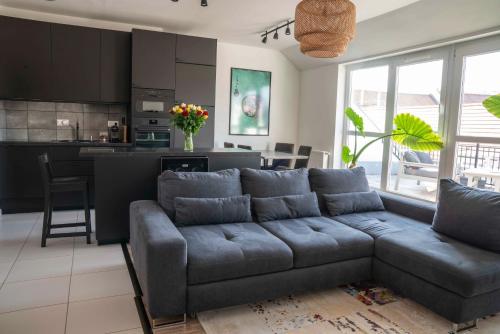 uma sala de estar com um sofá e uma cozinha em Taylor Apartman em Eger