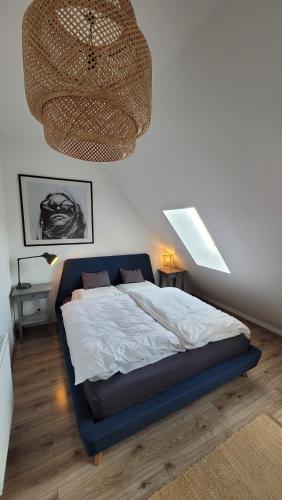 um quarto com uma cama grande e um lustre em Taylor Apartman em Eger