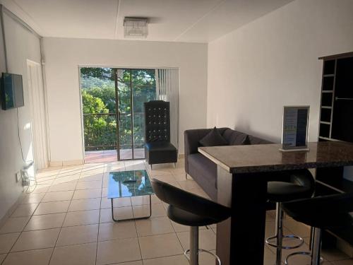 sala de estar con mesa y sofá en Seabreeze Modern Apartment sleeps up to 4 people, en Durban